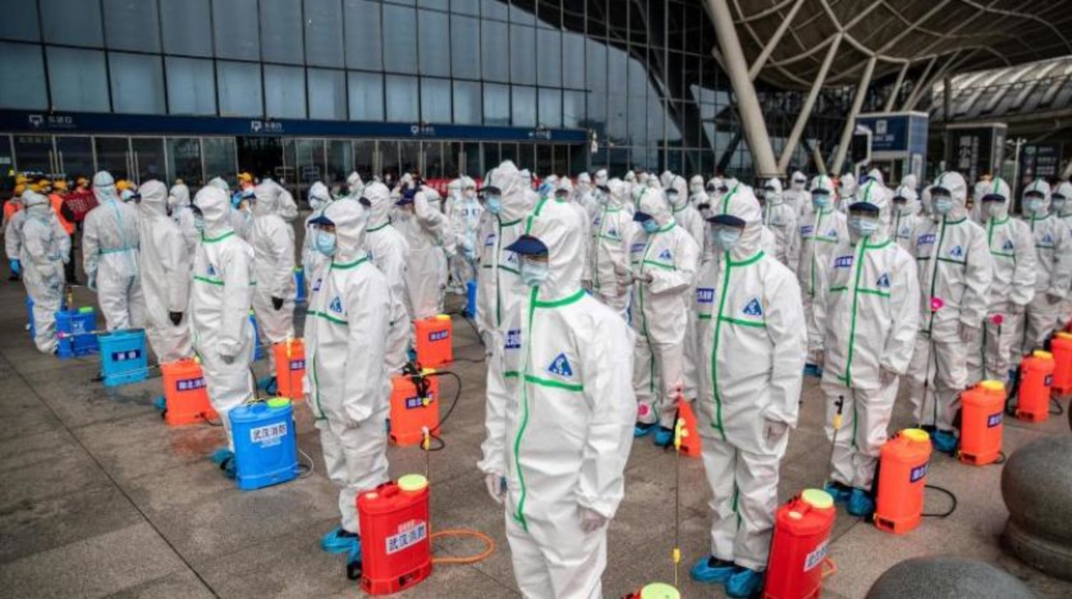 Wuhan şehrinde bir tren istasyonunu sterilize etmeye hazırlanan işçiler (AFP)