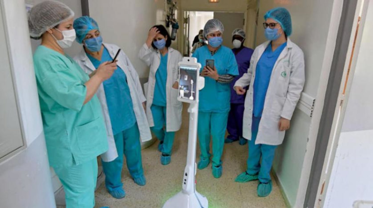 Hastanedeki sağlık personeli ve geliştirilen robot. (AFP)