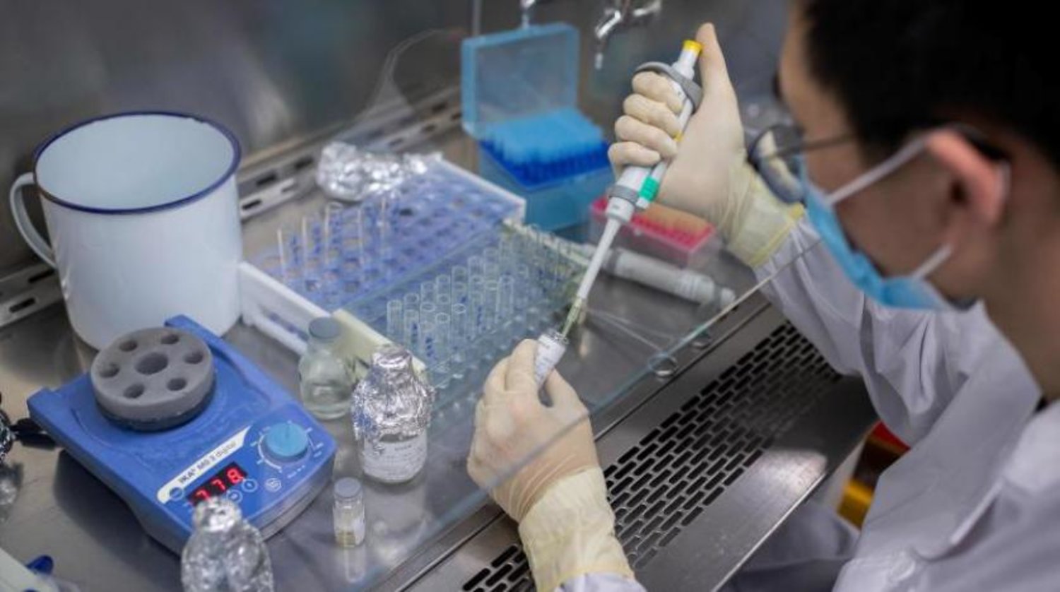 Pekin'de koronavirüs aşı denemeleri yapılan bir laboratuvardaki sağlık görevlisi (AFP)