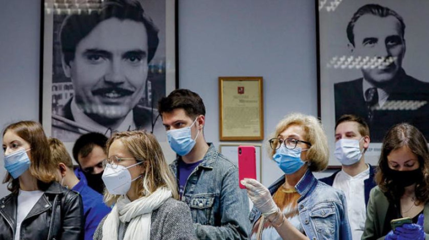 Rusya'nın geçen çarşamba günü geliştirdiği aşının ilk denemelerinin sona ermesiyle ilgili açıklamalarını dinleyen gazeteciler. (EPA)