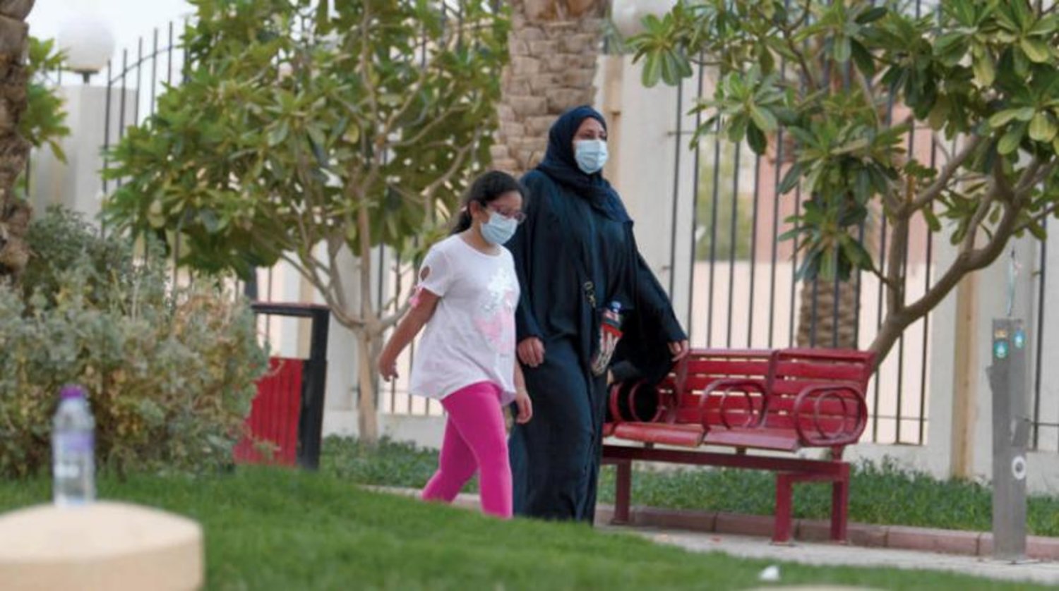Riyad'daki Prens Sultan Üniversitesi yakınların yürüyen ve koronavirüse karşı önlemlere riayet eden bir kadın ve kızı (Fotoğraf: Beşir Salih)