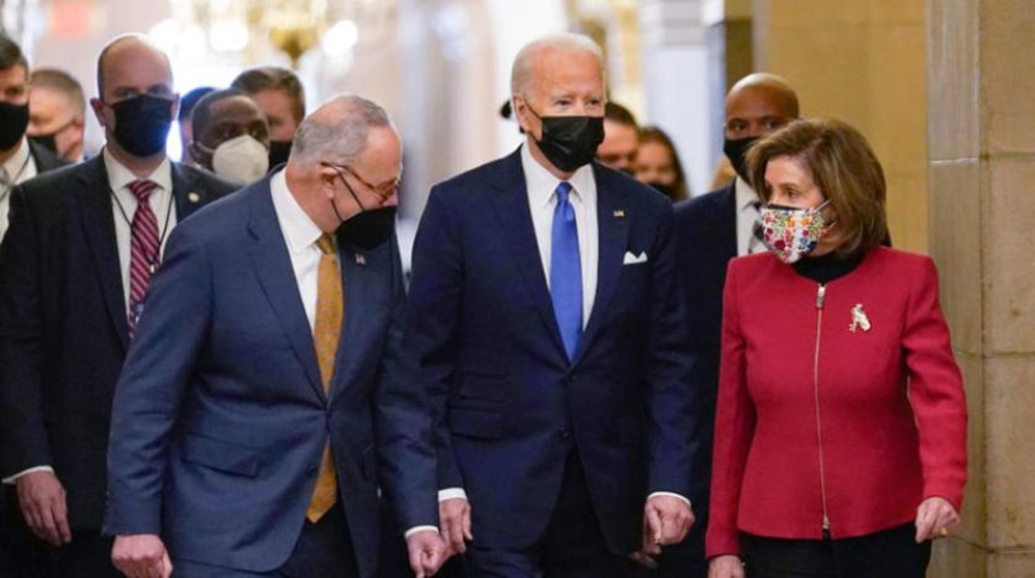 Biden geçtiğimiz hafta Kongre Binası’nda ABD Senatosu Çoğunluk Lideri Chuck Schumer ve Temsilciler Meclisi Başkanı Nancy Pelosi’nin ortasında yürürken (AP)