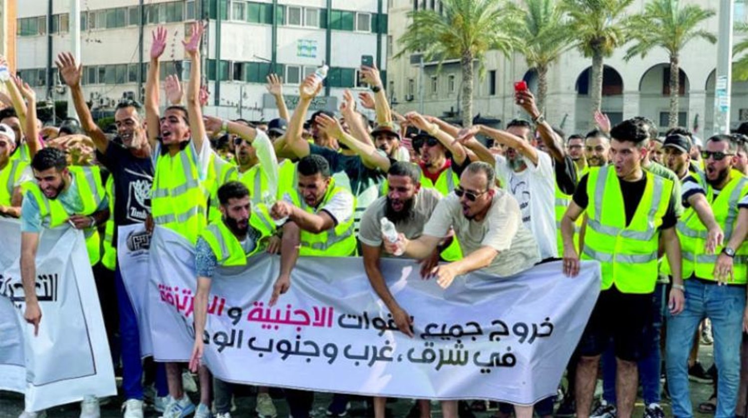 Trablus’un merkezinde düzenlenen protesto gösterisinde ‘Tüm yabancı güçler ülkenin doğusundan ve batısından ayrılsın’ yazılı bir pankart taşıyan Libyalılar (Reuters)