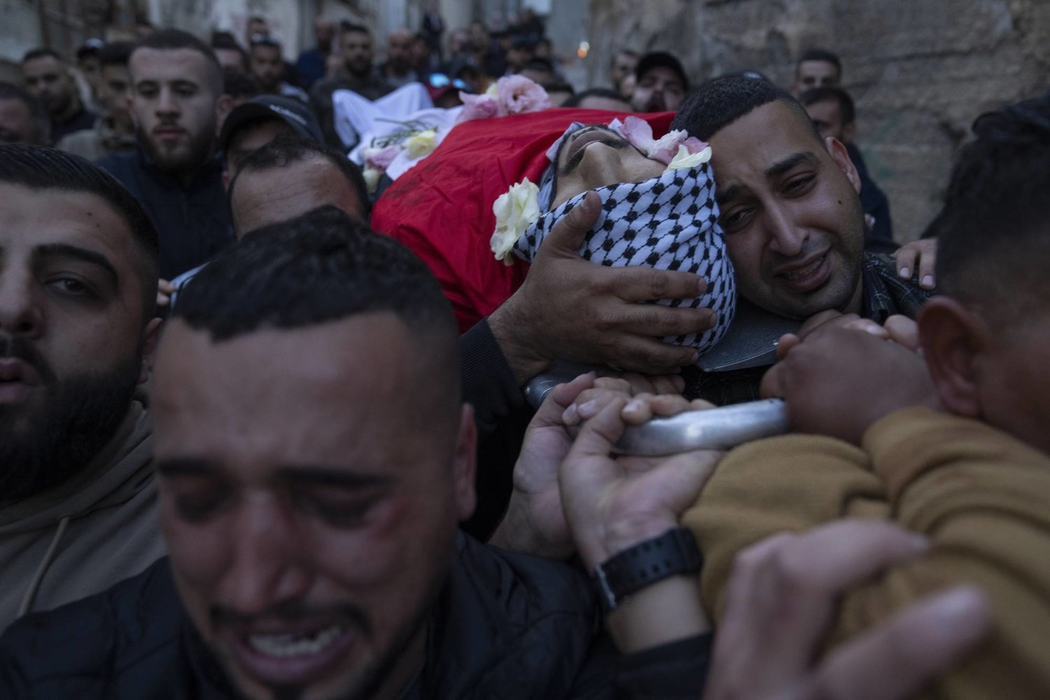 Filistinliler, dün Batı Şeria'daki Kalendiye Mülteci Kampı’nda İsrail'in açtığı ateş sonucu öldürülen Filistinli genç bir adamın naaşını taşıyor ( AP)