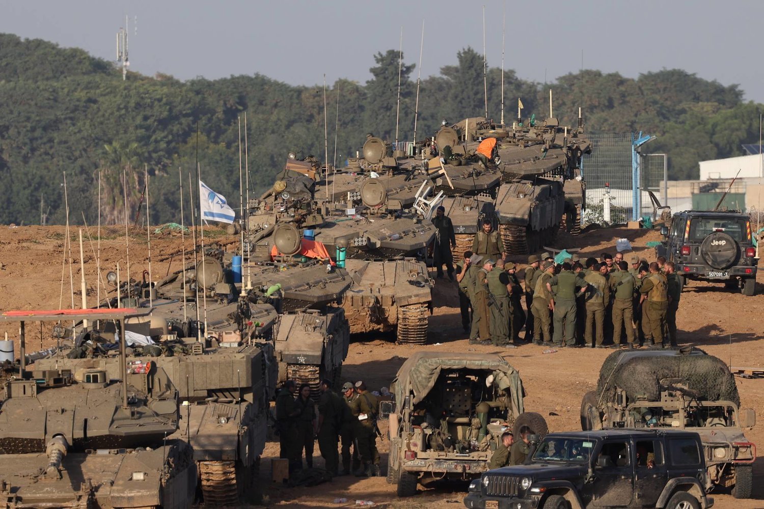 İsrail askerleri, İsrail'in güneyindeki Gazze sınırına yakın bir bölgede tankların yanında toplanırken (EPA)