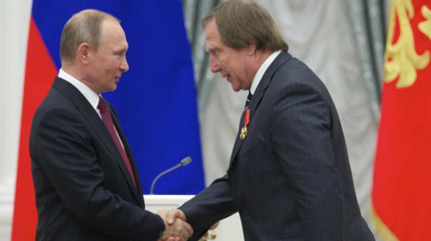 Rusya Devlet Başkanı Vladimir Putin, Moskova'da Sergey Roldugin ile el sıkışırken (AP)