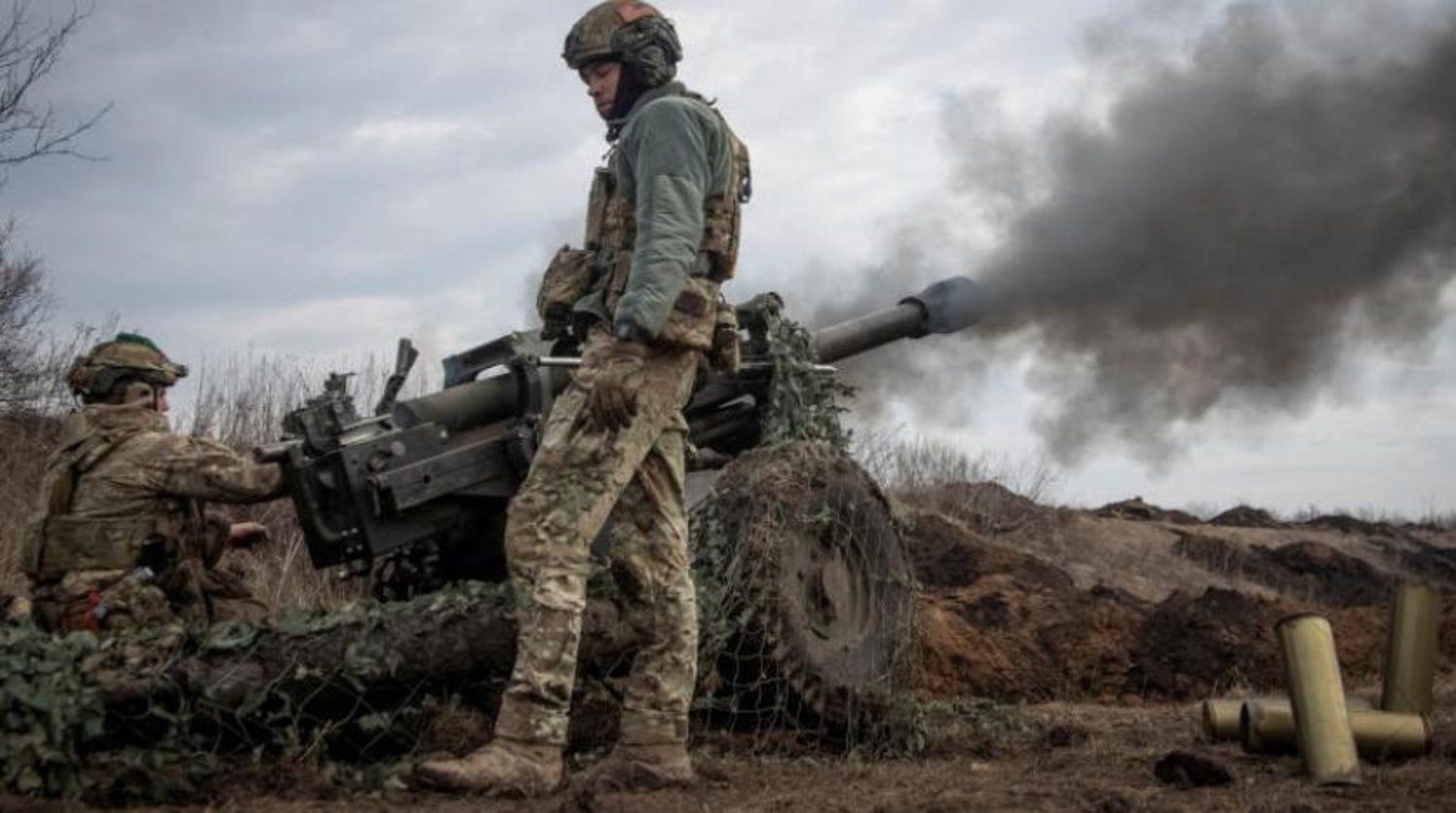 Ukraynalı bir asker, Bahmut yakınlarındaki cephe hattına bir M119 obüsü ateşliyor (Reuters)