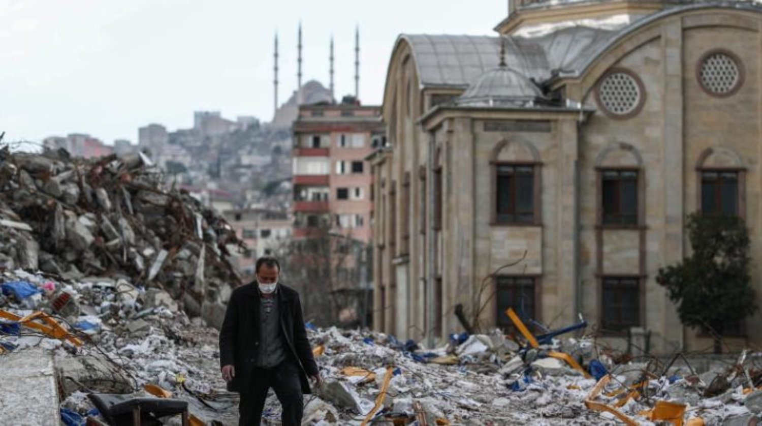 Kahramanmaraş'ta yıkıcı depremin kalıntıları arasında bir adam yürüyor  (EPA)
