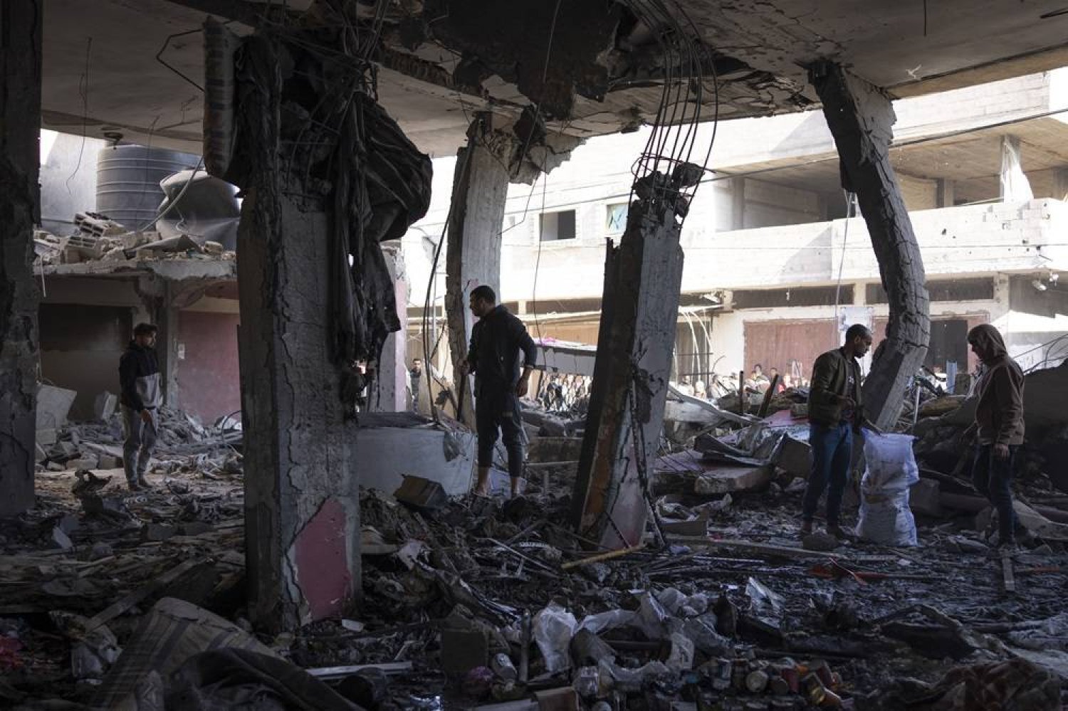 24 Şubat 2024 Cumartesi günü Filistinliler, Gazze Şeridi’ndeki Refah’a yönelik bir İsrail saldırısının ardından oluşan sonra enkazı inceliyor (AP)