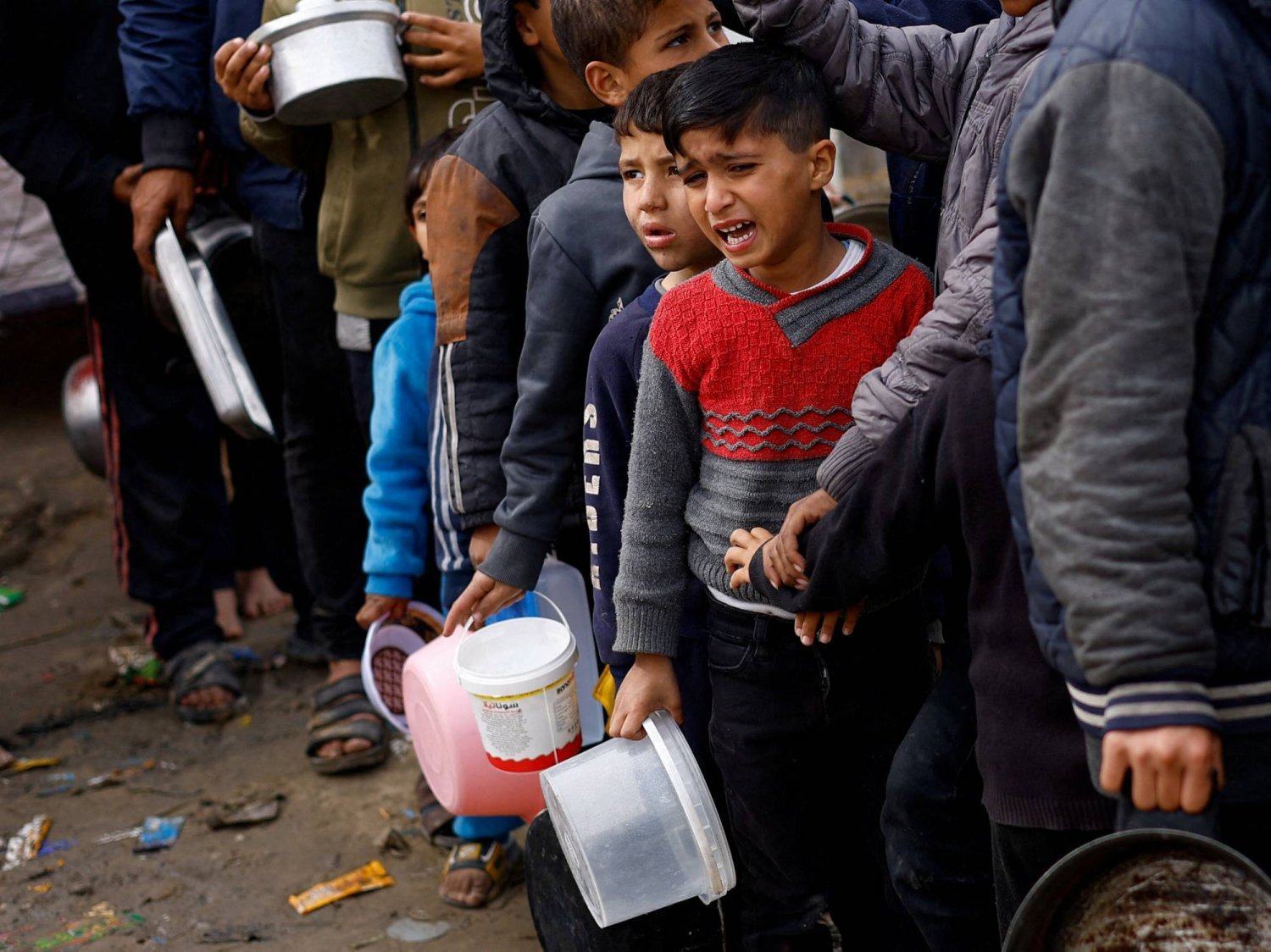 Gazze Şeridi'nin güneyindeki Refah'ta gıda sıkıntısı çeken Filistinliler, yardım mutfağından yiyecek almayı bekliyor (Reuters)