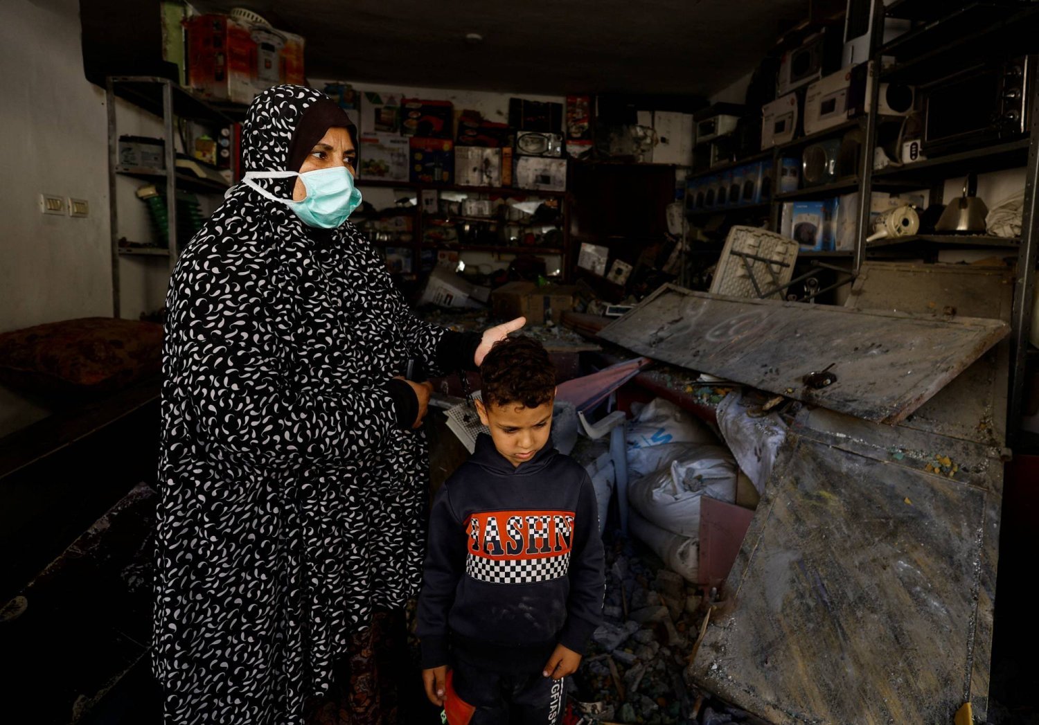Filistinli bir kadın ve çocuğu, İsrail'in Refah'ta bir evi bombalaması sonucu oluşan yıkımın ortasında duruyor. (Reuters)