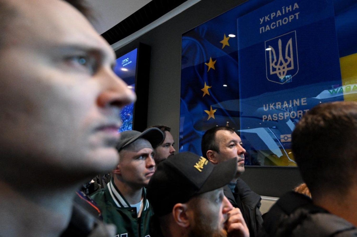 Polonya'nın Varşova kentindeki bir alışveriş merkezinde Ukraynalılar, Ukrayna'nın pasaport hizmet noktasının kapalı kapıları önünde (AFP)