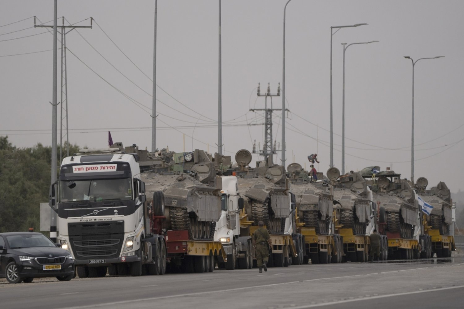 İsrail-Gazze sınırı yakınlarındaki bir yolda kamyonlarla taşınan İsrail zırhlı araçları, 25 Nisan 2024 (AP)