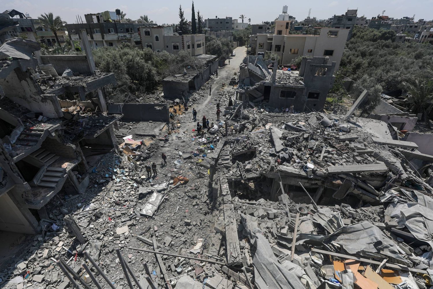 Gazze Şeridi'nin merkezindeki el-Meğazi Mülteci Kampı’nda yıkılan evlerini inceleyen Filistinliler (EPA)