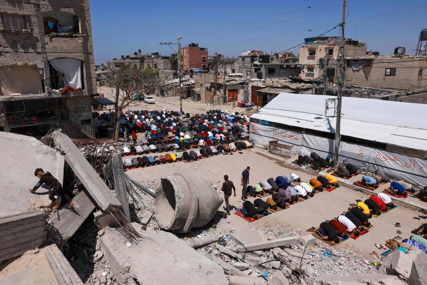 Refah'ta yıkılan el-Faruk Camisi’nin yanında Cuma namazı kılan Filistinliler (AFP)