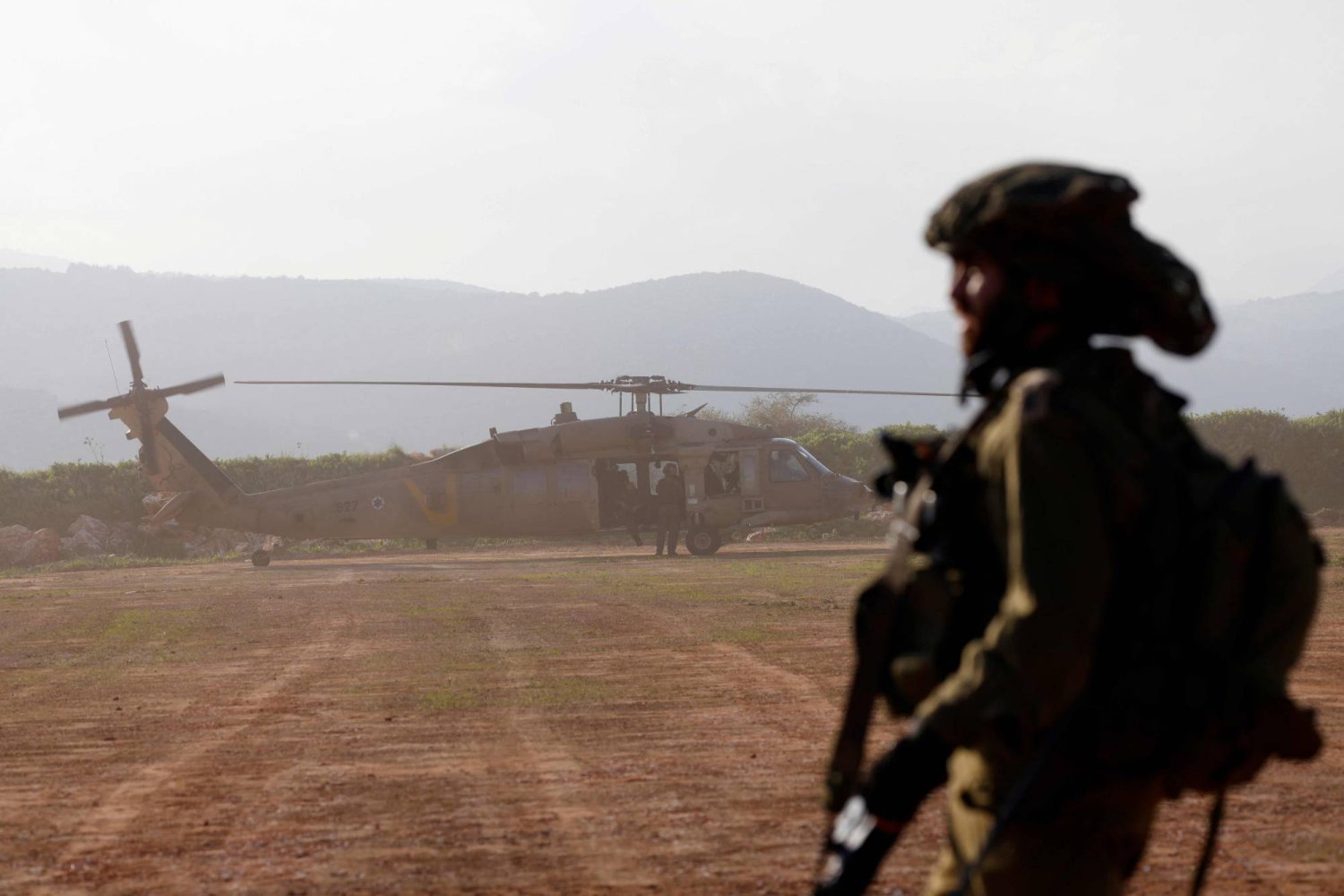Lübnan sınırı yakınındaki Yukarı Celile'de askeri eğitim tatbikatı sırasında havalanan helikoptere bakan İsrailli bir asker (AFP)