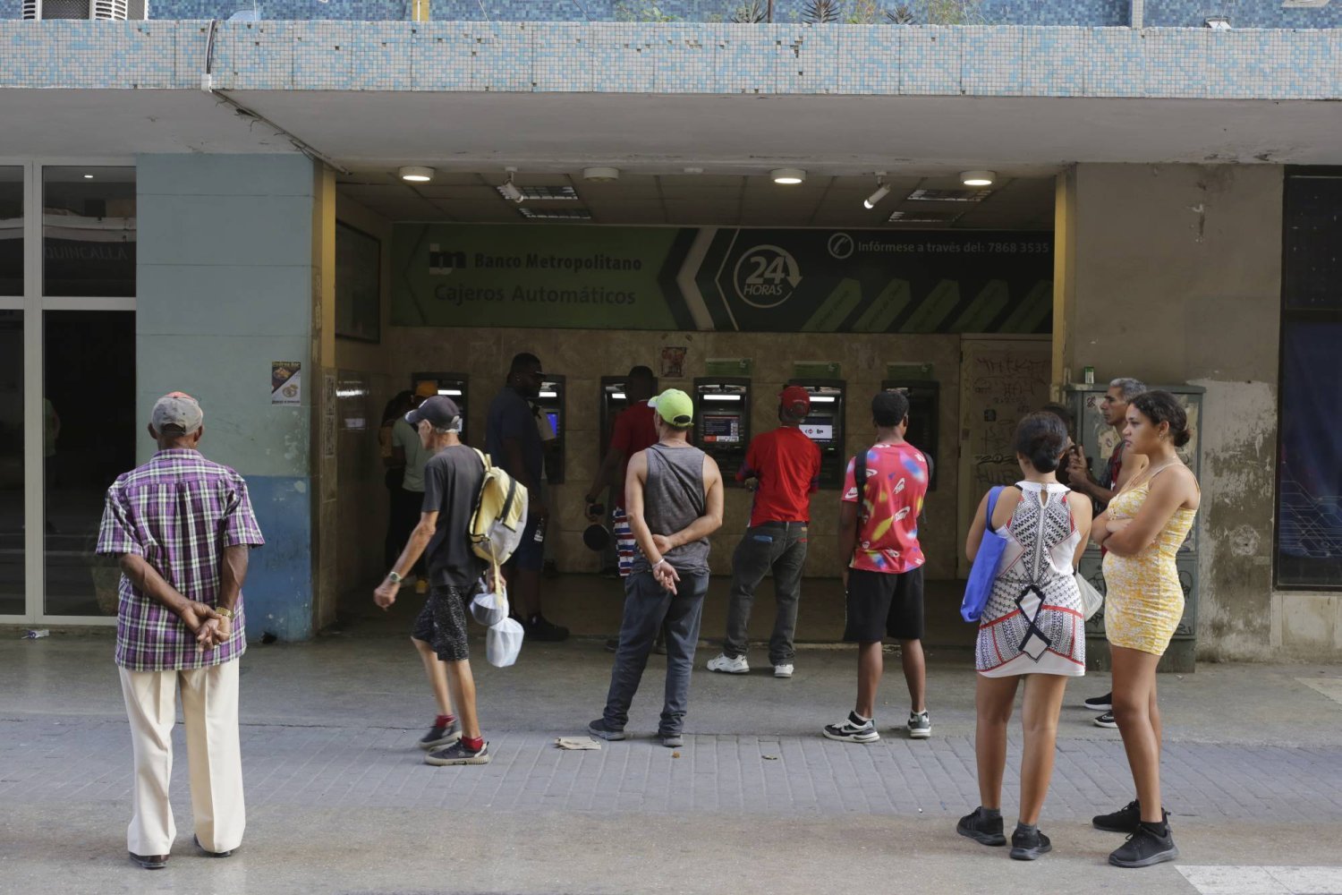 Kübalılar, likidite sıkıntısı krizinin ortasında biraz para almayı umarak bankamatiklerin önünde bekliyor (AP)