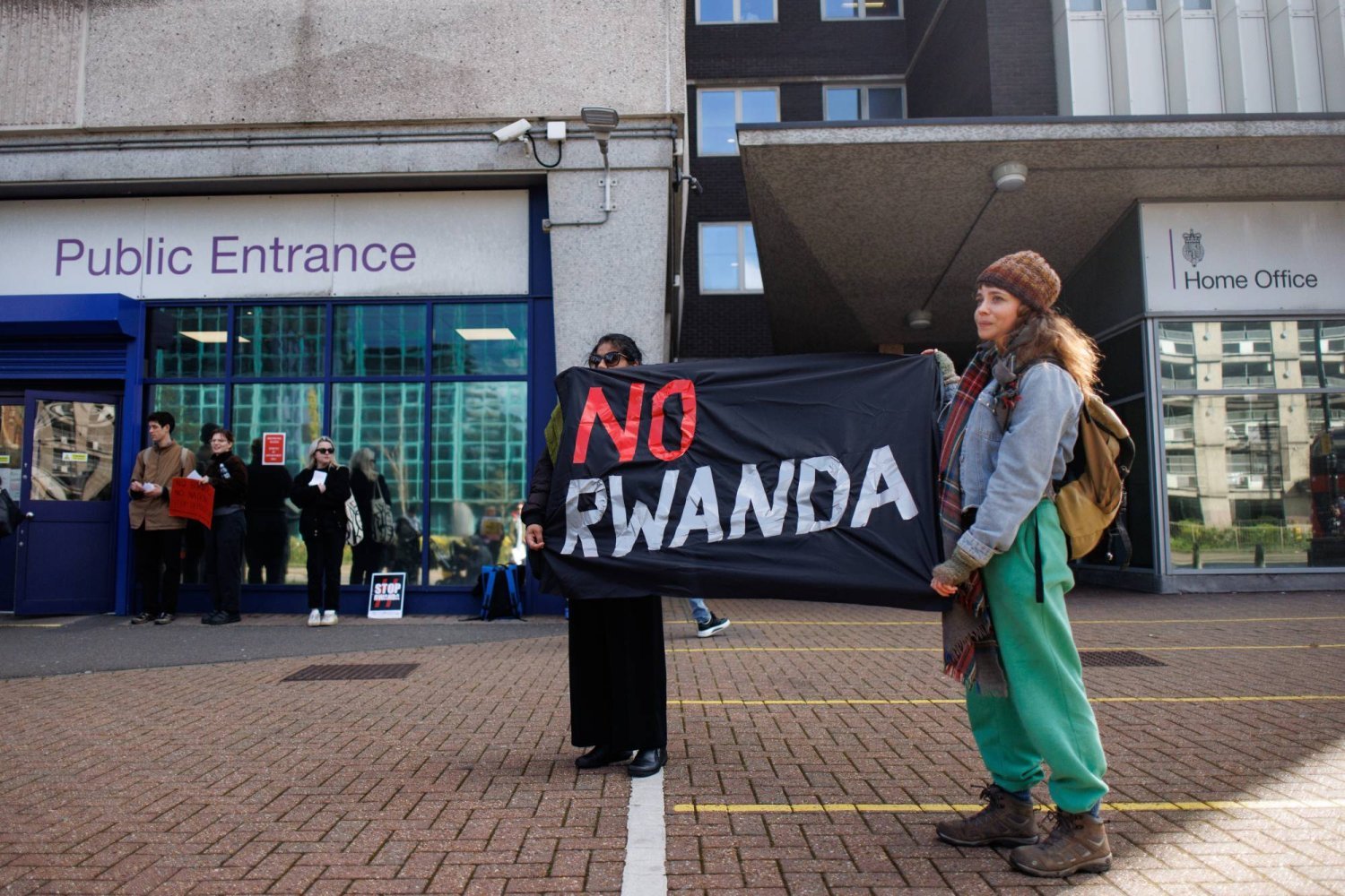 Aktivistler, İngiliz hükümeti tarafından kabul edilen Ruanda'ya sınır dışı etme yasasını Güney Londra'daki göçmenlik merkezinin önünde protesto etti (EPA)