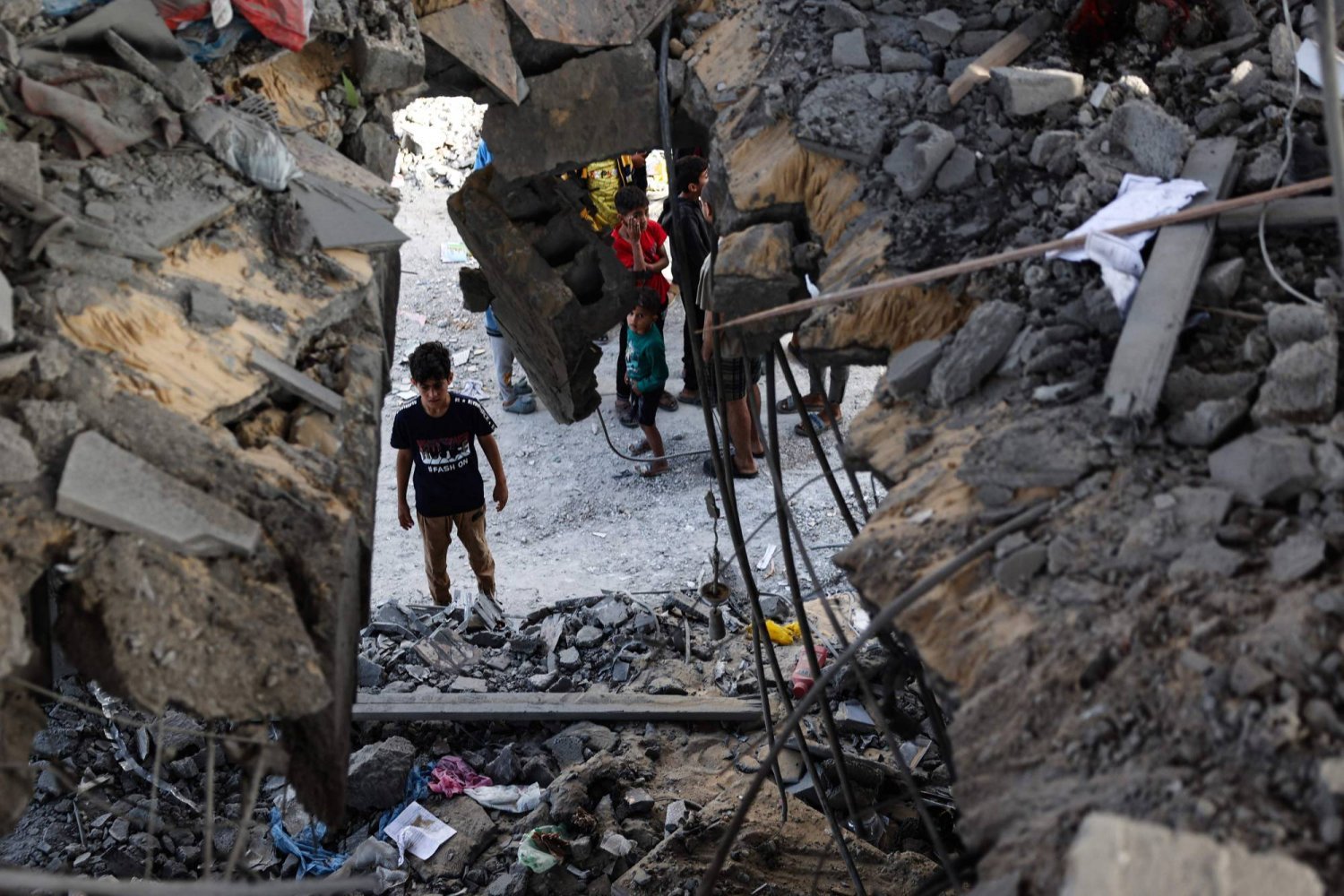 Gazze Şeridi'nin güneyindeki Refah kentinde İsrail bombardımanının yol açtığı yıkımı inceleyen Filistinliler (AFP)