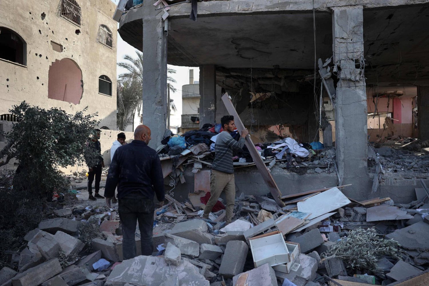 Refah'ta İsrail bombardımanını sonrası meydana gelen hasarı inceleyen Filistinliler (AFP)
