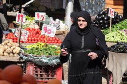 Kahire'nin Abidin bölgesinde bir sebze pazarında dolaşan Mısırlı kadın (EPA)