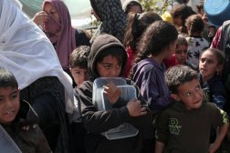 Filistinli çocuklar yiyecek almak için Gazze Şeridi’nin güneyindeki Refah’ta bekliyor (AFP)